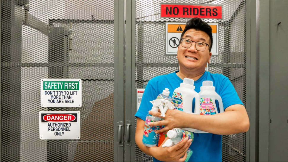 Man holding Truly Free brand cleaning bottles in front of an industrial elevator.