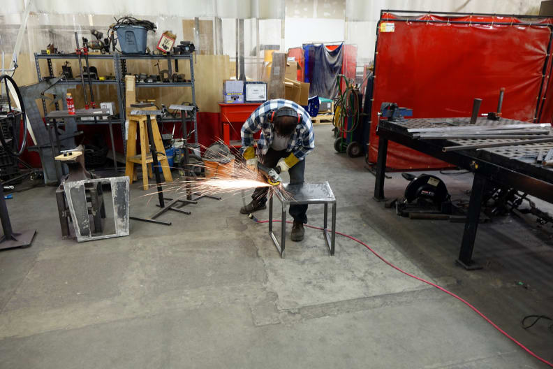 A man sawing into a piece of metal.