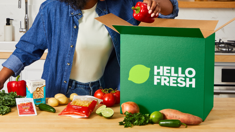 A variety of HelloFresh ready made meals, including couscous bowls, toast with salad, and egg bites, displayed with recipe cards on a kitchen counter.