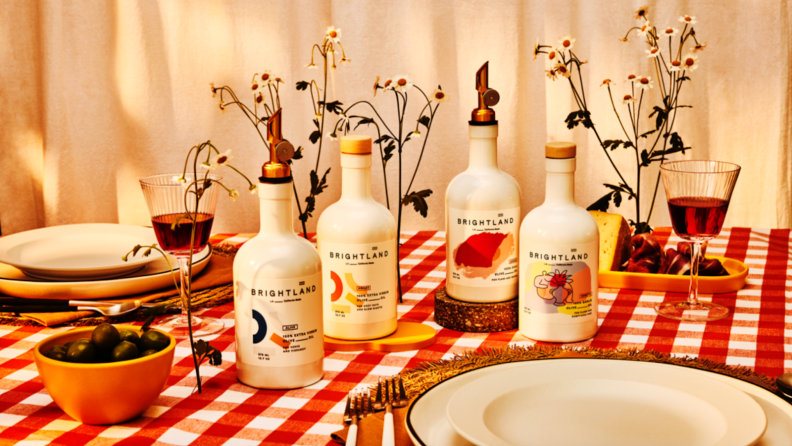 Several bottles of Brightland's olive oils in the middle of table spread.