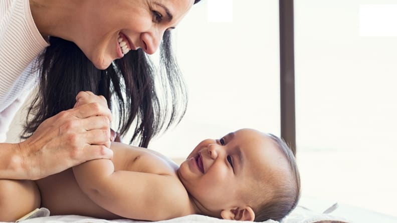 A mother smiles at a smiling baby.