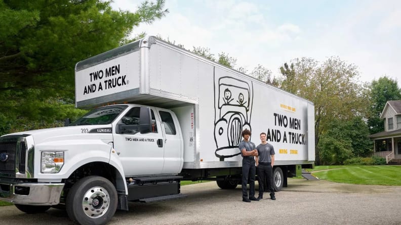 Two movers and a white truck behind them