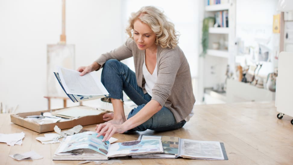 A person sorts through personal photographs at home.