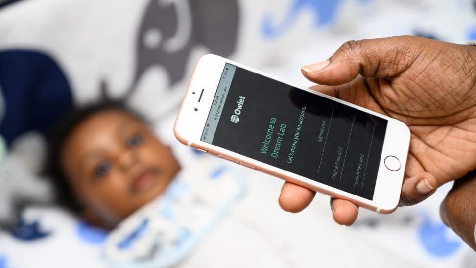 Woman with baby holding phone with Owlet Dream Lab program