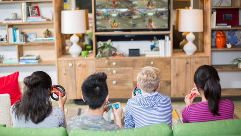 Family sitting on the couch playing Nintendo Mario Kart