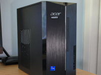 A black Acer desktop computer tower sits on top of a desk next to a computer monitor.