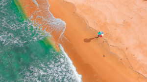 Aerial shot of a lone beach umbrella on a beach