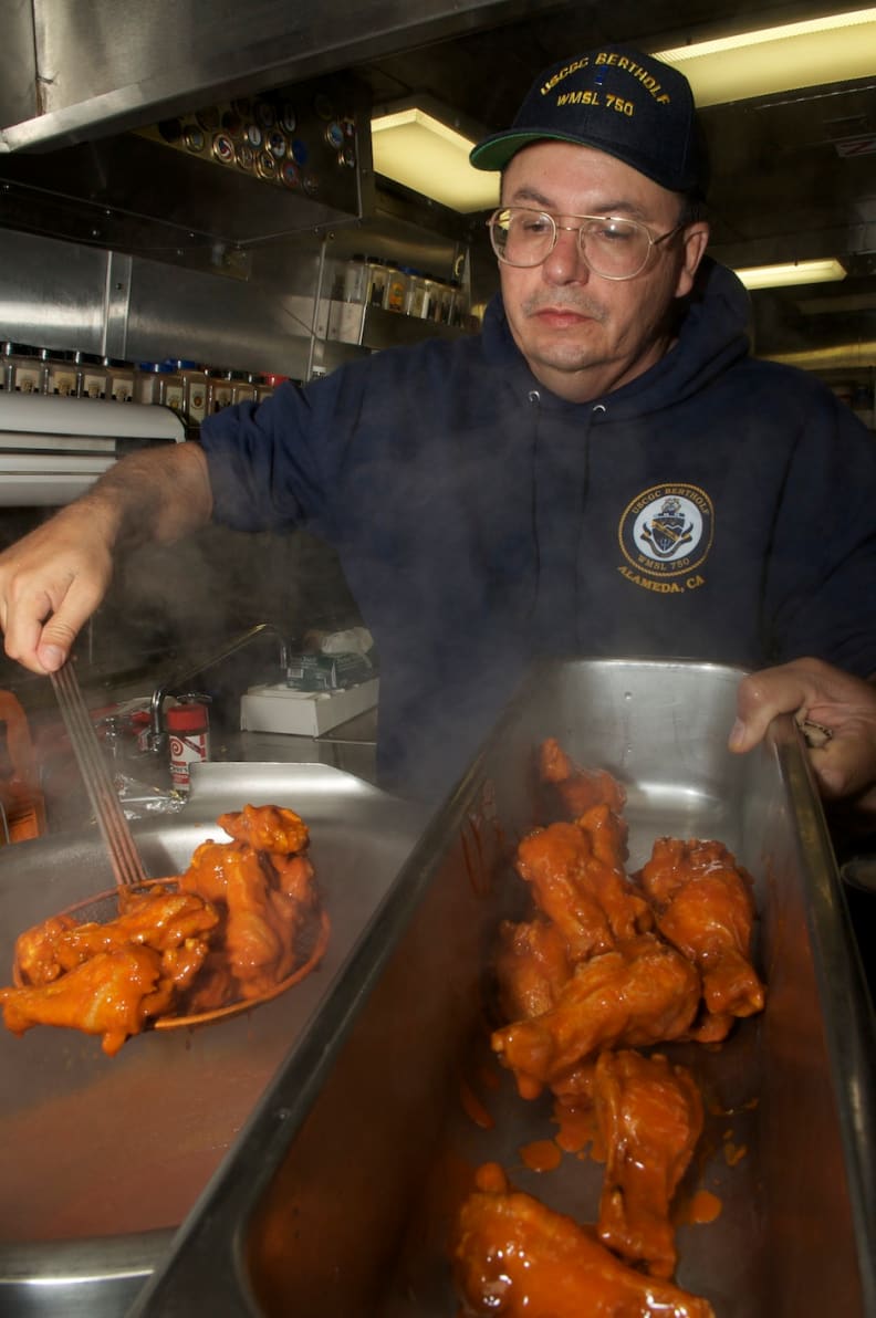 A cook preps Buffalo wings.