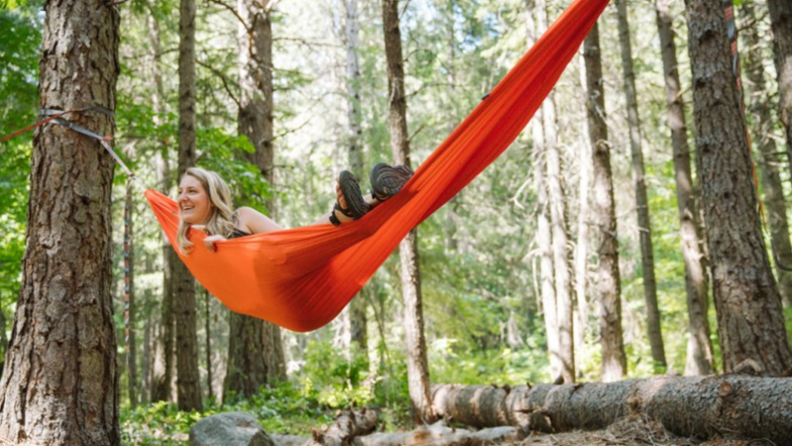 Woman lying in an orange hammock