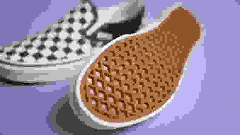 Close-up shot of the Vans Checkered slip-ons, with one of them showing the sole.