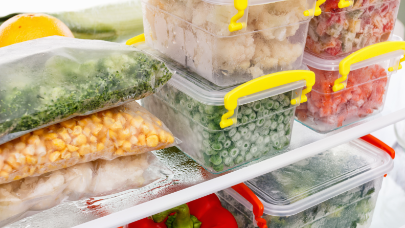 Several containers and bags of food stored in a freezer