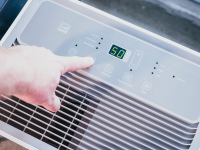 A Hisense DH7021K1W, one of the best dehumidifiers, is shown from the top, with a hand controlling it.