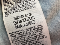 A clothing tag on a vest with wash instructions.