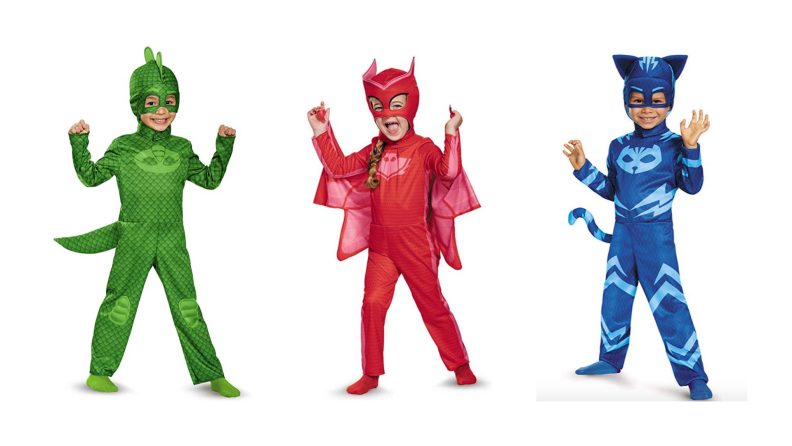 Three young children dressed up as the characters from PJ Masks: Gekko, Cat Boy, and Owlette.