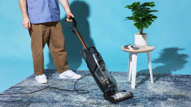 A person using Bissell CrossWave HydroSteam vacuum wet/dry vacuum on carpet.