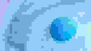 A blue bath bomb starts to foam turning the water around it different shades of blue.