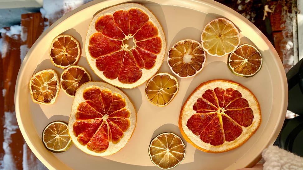 There are 12 pieces of dehydrated citrus slices on a plate, including grapefruit, lemon, and lime.