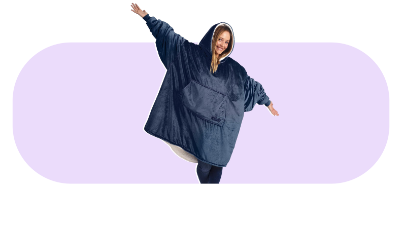 Model smiling while wearing navy oversized blanket sweatshirt.