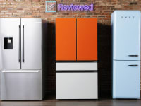 Three different refrigerators standing against a brick wall