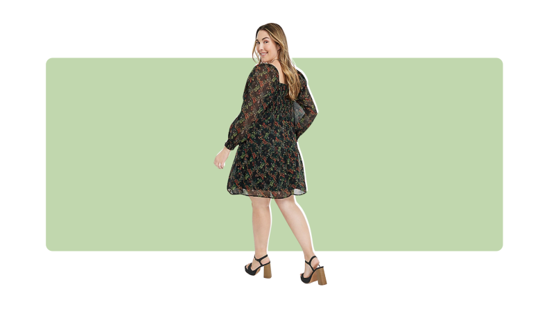 A black knee-length dress with a small floral print throughout.