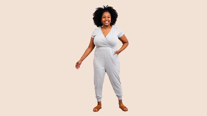 A woman wearing  Latched Mama Play All Day Nursing Jumpsuit in the color grey.
