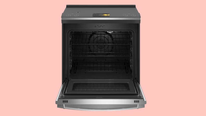 An open stainless steel oven against a pink background.