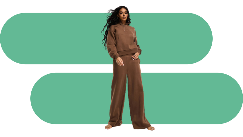A model wearing a brown sweatsuit with a half zip sweatshirt and wide-leg pants.