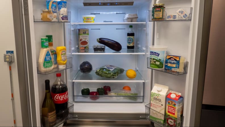 The open fridge showcases all kinds of products, products and condiments inside.