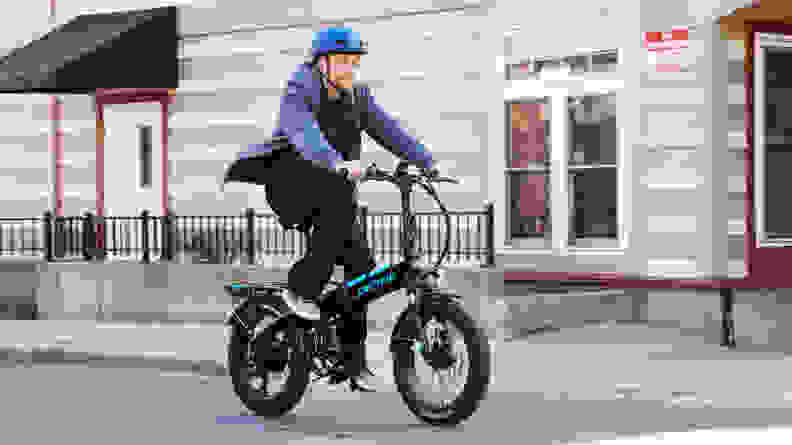 A tester from Reviewed rides an e-bike down the street