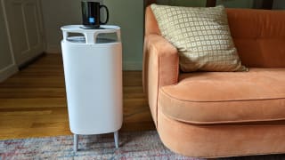 A Blueair dustmagnet air purifier stands holding a coffee cup on its tabletop