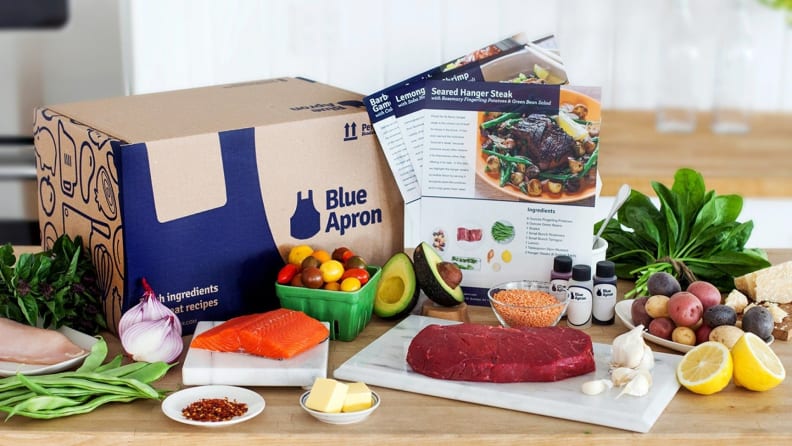 Blue Apron box with ingredients and menu cards in front