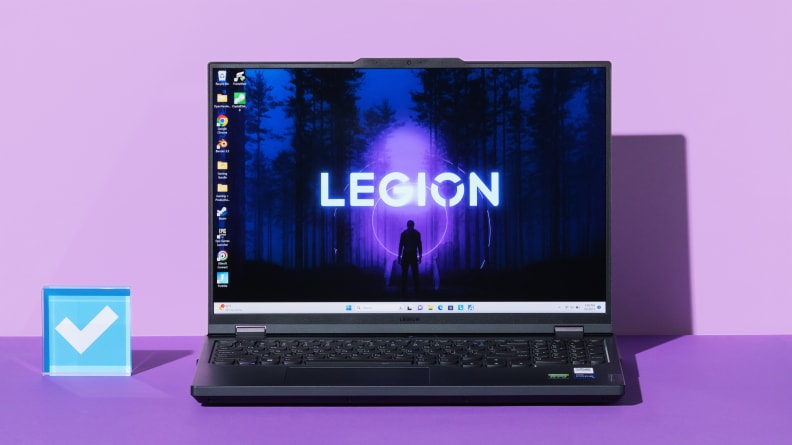 An open and powered on black laptop against a purple background