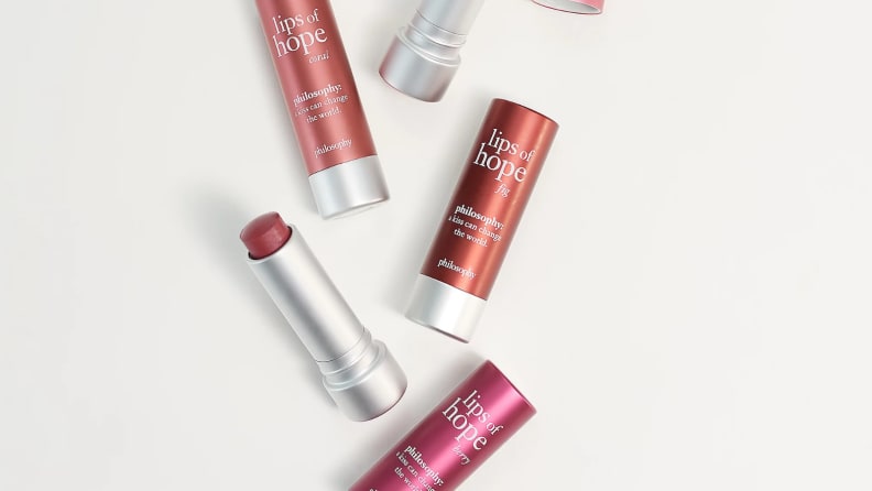 An image of several tubes of philosophy lip stick and moisturizer, in different shades ranging from coral pink to rosy pink.