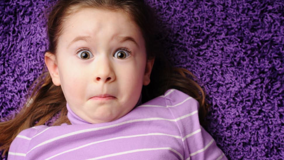 Girl with surprised face laying on purple carpet