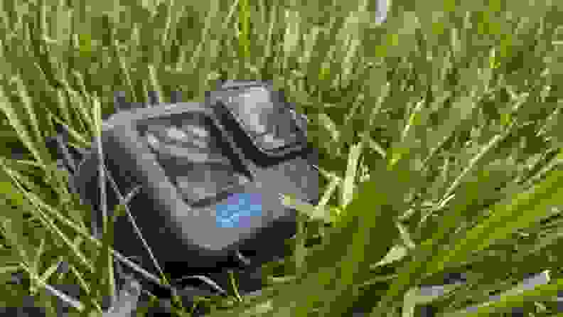 The GoPro Hero12 Black on the ground surrounded by grass in an outdoor setting.