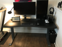 A computer desk with two monitors, a radio, and keyboard.