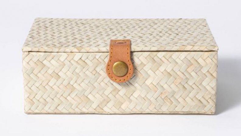 A rattan keepsake box against a gray background.