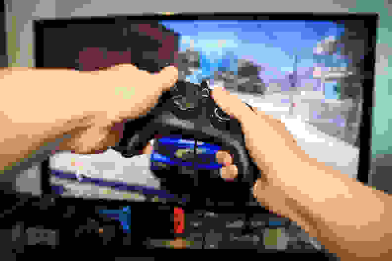 A pair of hands holding the controller to play video games.