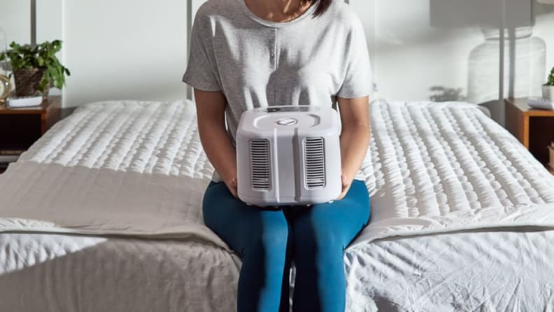 a woman holds a chilipad cooling cube on her lap