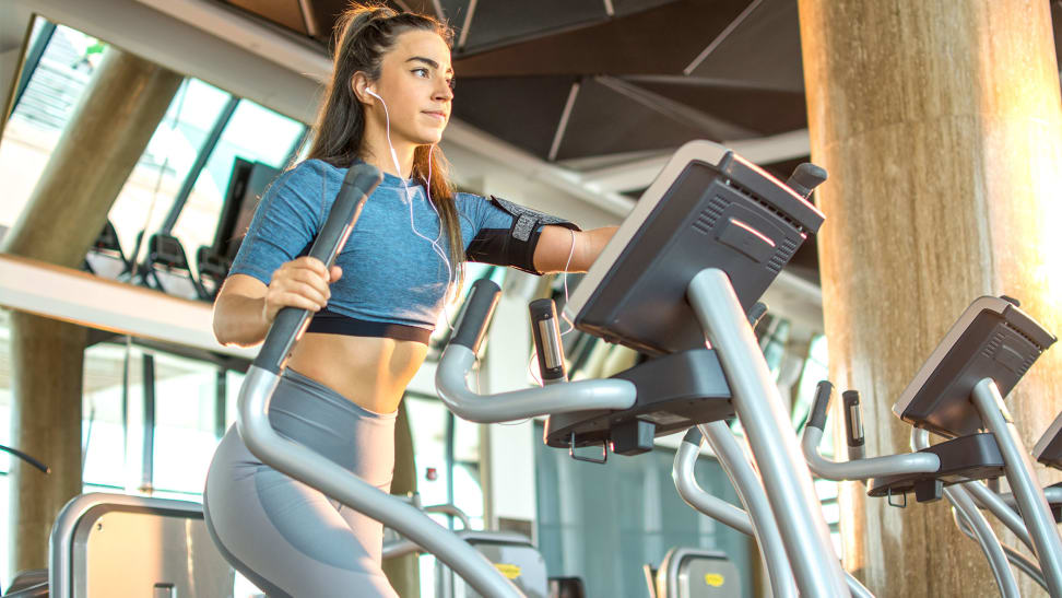 A woman using the elliptical machine at the gym.