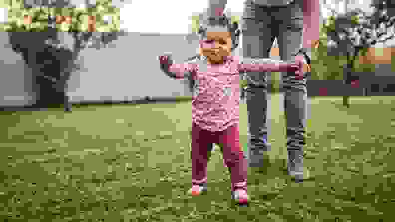 Shot of an adorable baby girl having fun with her dad in their backyard