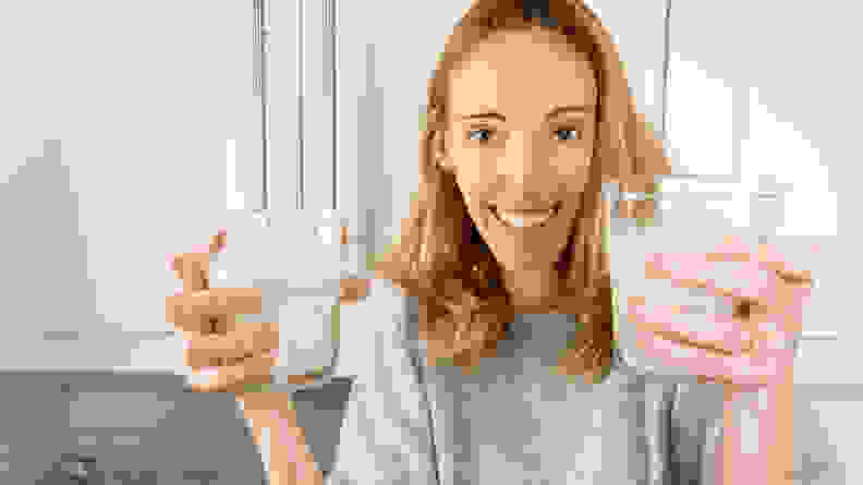 Woman holding two glasses of almond milk