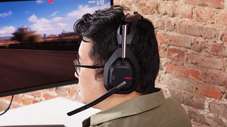 A man wearing a Logitech Astro A50 X, one of the best gaming headsets on the market