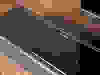 索尼的所有黑色的声音坐落在一张木桌子上，一个银色索尼徽标在左边的玻璃面板上闪烁在玻璃面板上，在其上流驾驶员覆盖着声织物。