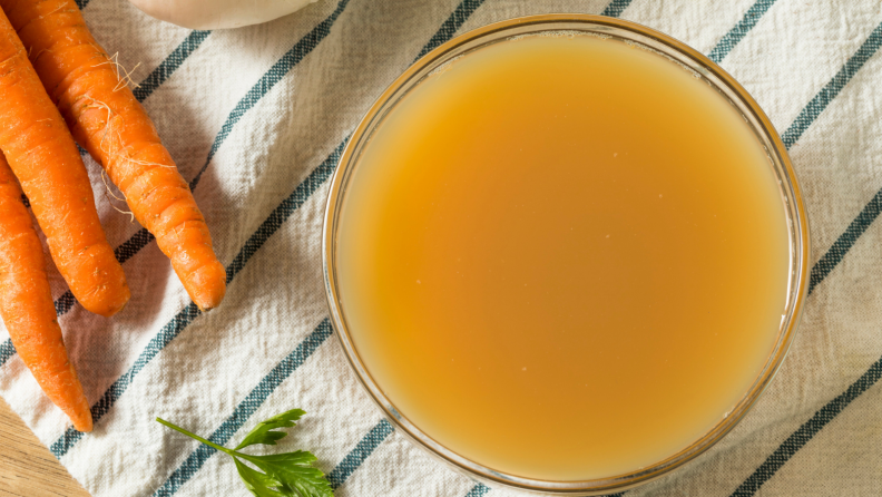 A glass bowl of turkey stock, shot from above.