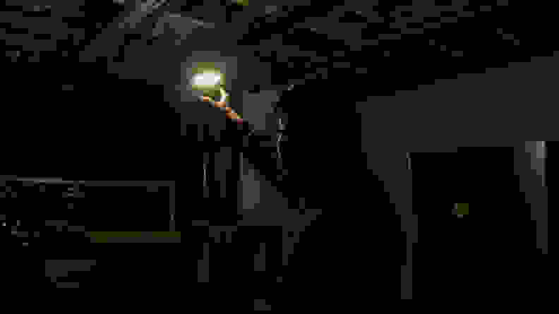 A man using the M150's ring light to illuminate a dark basement.
