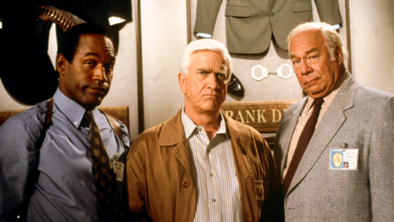 O. J. Simpson, Leslie Nielsen, and George Kennedy pose on the set of the 1988 comedy The Naked Gun.