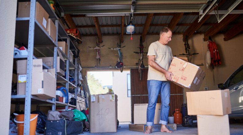 A man moves a box inside of a garage