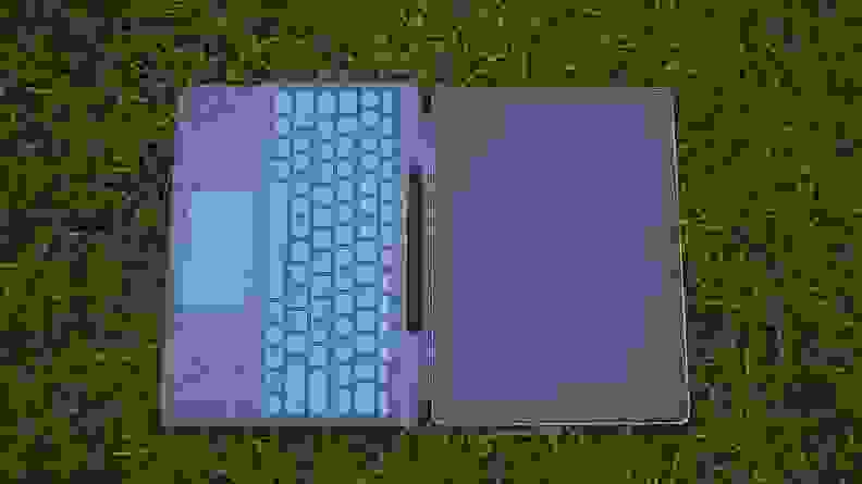 The Surface Pro X laid atop grass with the Surface Keyboard attached.