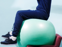 表演艺术家在健身球和椅子上保持平衡。